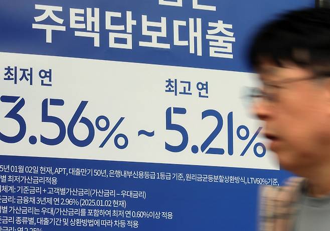 카카오뱅크가 30일부터 주담대 가산금리를 0.2%포인트 올린다. 사진은 서울 시내의 한 은행 입구에 주택담보대출 상품 금리 홍보물 앞으로 시민이 지나고 있다./사진=뉴스1