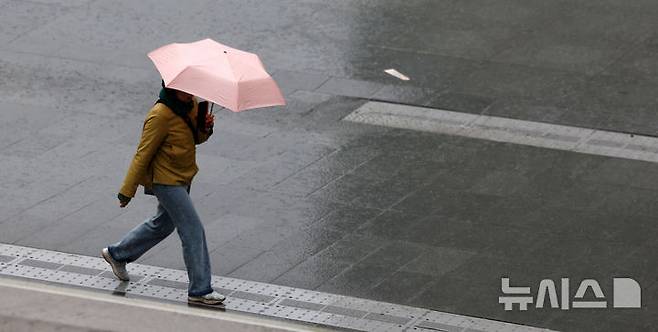 [서울=뉴시스] 김선웅 기자 = 수도권에 봄비가 내린 14일 서울 종로구 광화문광장에서 우산을 쓴 시민이 길을 걷고 있다. 2025.04.14. mangusta@newsis.com