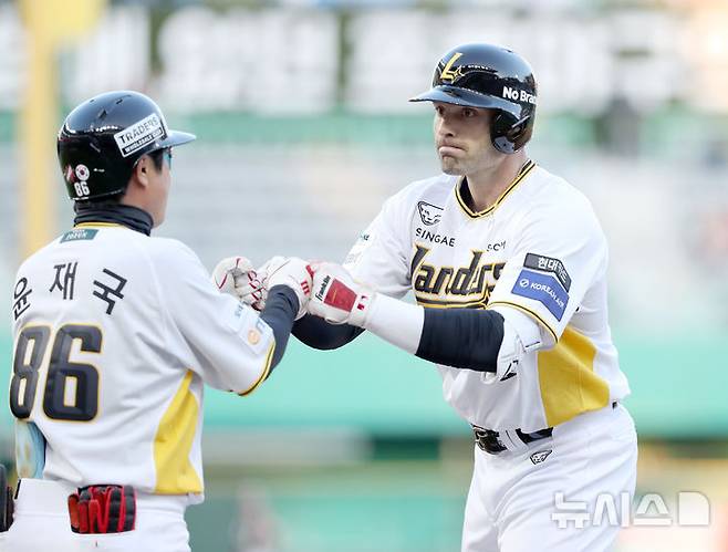 [서울=뉴시스] 프로야구 SSG 랜더스 라이언 맥브룸(오른쪽)이 25일 인천 SSG랜더스필드에서 열린 2025 신한 쏠뱅크 KBO리그 키움 히어로즈와의 경기에서 적시타를 친 뒤 윤재국 코치와 손을 맞대고 있다. (사진=SSG 랜더스 제공) 2025.04.25.