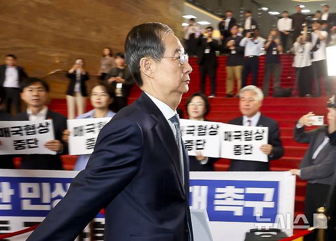 [서울=뉴시스] 국회사진기자단 = 한덕수 대통령 권한대행 국무총리가 24일 서울 여의도 국회에서 열린 본회의에서 2025년도제1회추가경정예산안에대한정부의시정연설을 위해 국회 본청으로 들어서고 있다. 한 대행 뒤로 야4당(조국혁신당, 진보당, 기본소득당, 사회민주당) 의원들이 한 대행을 규탄하는 피켓을 들고 있다. 2025.04.24. photo@newsis.com