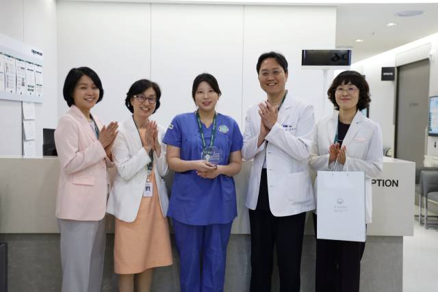최애리(왼쪽에서 세 번째) 이대목동병원 간호사가 28일 이비인후-두경부외과 외래에서 감사패를 받은 후 병원의 주요 임직원들과 함께 기념사진을 찍었다. 사진 제공=이대목동병원