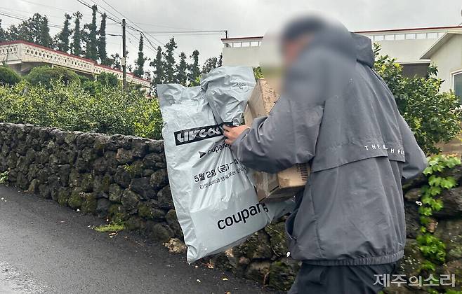 쿠팡 택배 기사 한씨가 비를 맞으며 물품을 배송하는 모습. ⓒ제주의소리