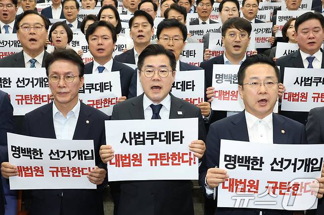 더불어민주당 21대 대선 상임 총괄선대위원장인 박찬대 당대표 직무대행 겸 원내대표와 의원들이 1일 오후 서울 여의도 국회에서 열린 긴급 의원총회에서 이재명 대통령 후보의 공직선거법 위반 혐의에 대해 대법원이 유죄 취지의 파기 환송 결정한 것에 대해 규탄 구호를 외치고 있다. 2025.5.1/뉴스1 ⓒ News1 이광호 기자