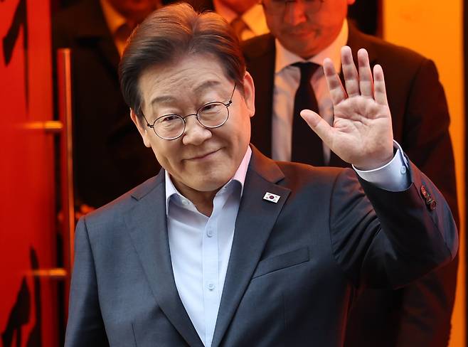 이재명 더불어민주당 대통령 후보가 1일 서울 종로구의 한 포차 식당에서 '당신의 하루를 만드는, 보이지 않는 영웅들'이란 주제로 열린 배달 라이더, 택배 기사 등 비(非)전형 노동자들과 간담회를 마친 뒤 나서며 손인사를 하고 있다./뉴스1