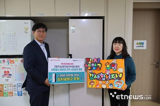 서재형 KIAPI 원장(왼쪽)이 지역아동센터 관계자에게 김치냉장고를 전달하고 있다.
