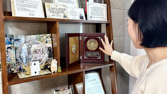 4월 22일 서울 서대문구 자택에서 고(故) 유재국 경위의 아내 이꽃님(38)씨가 유 경위의 초상이 새겨진 기념패를 어루만지고 있다. 한강경찰대 소속 유 경위는 지난 2020년 2월 한강 투신자를 수색하다 순직했다. 이아미 기자