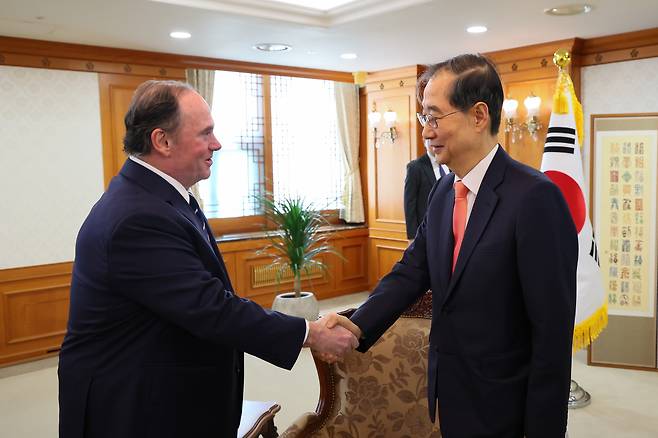 US Navy Secretary John Phelan (left) and Han Duck-soo, who was then South Korea’s acting president and prime minister, shake hands after a meeting during Phelan‘s visit to Korea on Wednesday in Seoul. (Yonhap)