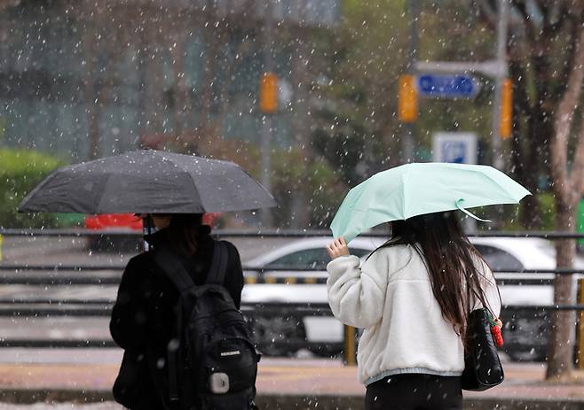 지난달 13일 서울 중구 명동 인근에서 우산을 쓴 시민들이 우박을 피하고 있다. [사진 = 연합뉴스]