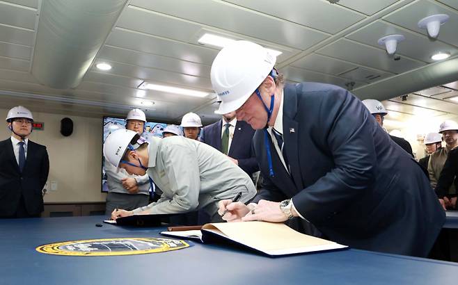 존 펠런 미 해군성 장관이 HD현대중공업이 건조한 최신예 이지스 구축함 '정조대왕함'에 승선해 방명록에 서명하고 있다/사진제공=HD현대중공업