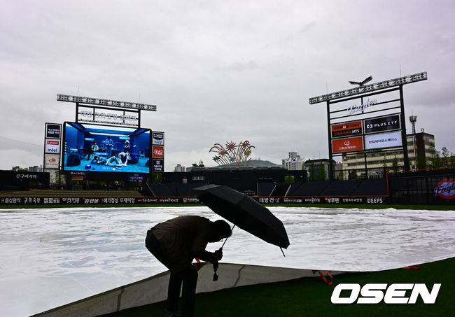 [OSEN=대전, 지형준 기자] 1일 대전 한화생명볼파크에서 2025 신한 SOL Bank KBO리그 한화 이글스와 LG 트윈스의 경기가 열린다.이날 한화는 엄상백, LG는 손주영이 선발로 나선다.이날 비 예보가 있는 가운데 한화생명볼파크에 비가 내리고 있다. 김시진 경기감독관이 그라운드를 살피고 있다. 2025.05.01 /jpnews@osen.co.kr