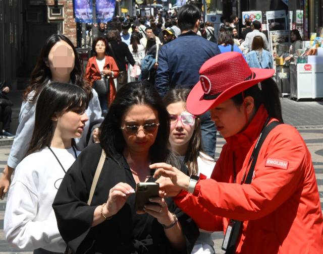 29일 서울 중구 명동거리를 찾은 한 외국인 관광객이 안내원으로부터 도움을 받고 있다. 오승현 기자