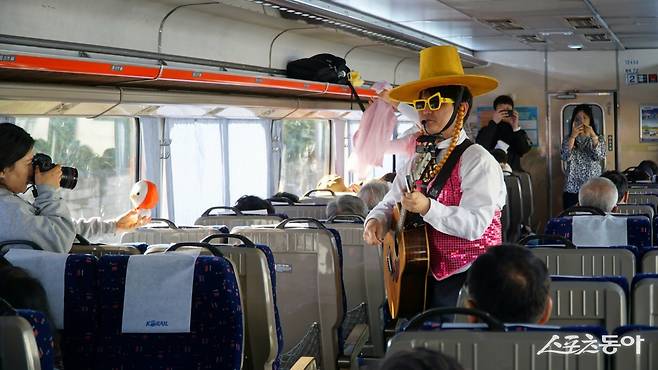 ‘충남 레트로 낭만열차’에서 진행하는 프로그램 중 하나안 싱어롱 타임. 통기타 반주에 맞춰 ‘여행을 떠나요’같은 예전 낭만을 일깨우는 노래를 함께 부르며 즐거운 추억여행으로 떠난다  충남｜김재범 기자 oldfield@donga.com