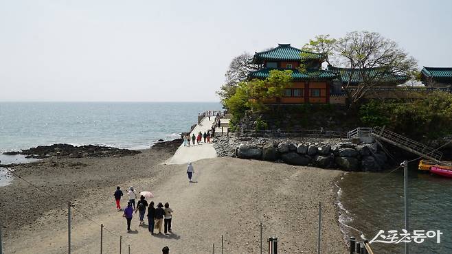 간조 때 섬과 이어진 길을 따라 간월암으로 가는 관광객들. 간월암을 찾을 때는 물때를 잘 계산해야 만조와 간조 때의 극적인 변화를 볼 수 있다          충남｜김재범 기자 oldfield@donga.com