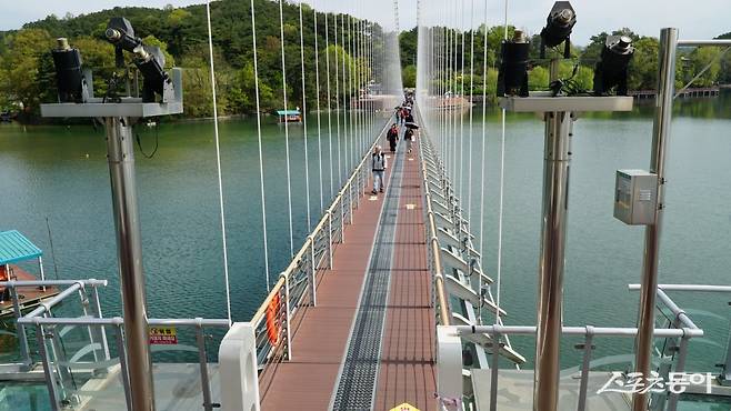 예산 예당호 출렁다리를 걸어가는 관광객들. 성인 3150명을 동시에 수용할 수 있는데, 바다 위 배처럼 부드럽게 출렁이는 다리는 걷는 재미가 있다 충남|김재범 기자 oldfield@donga.com