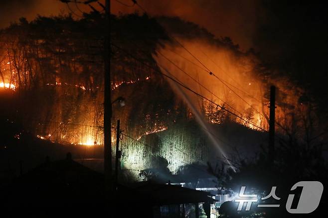 경남 산청 대형 산불 닷새째인 25일 오후 산청군 시천면 일대에서 민가 뒤로 불길이 치솟고 있다. 2025.3.25/뉴스1 ⓒ News1 윤일지 기자