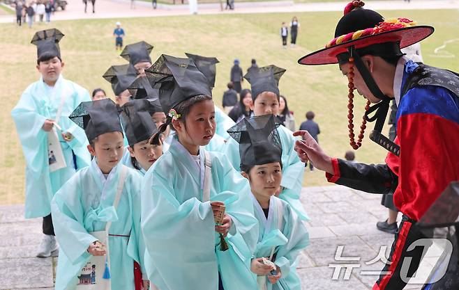 2일 오후 서울 종로구 경희궁에서 열린 '영조와 함께하는 조선시대 경희궁 유생 체험'에 참가한 어린이들이 과거 시험을 보기 위해 수문장에게 호패를 보여주고 있다. 2025.5.2/뉴스1 ⓒ News1 장수영 기자