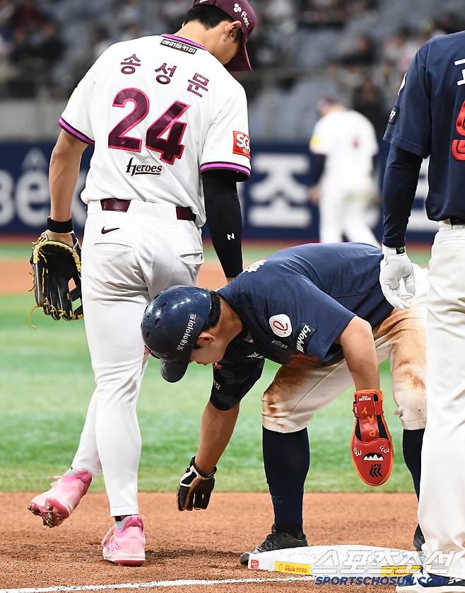 종아리를 꼬집힌 송성문이 오른발을 빼고 있다.