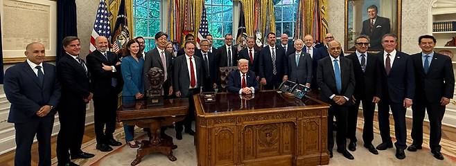 도널드 트럼프 미국 대통령(앞줄 책상에 앉은 사람)이 지난달 30일(현지 시간) 워싱턴 백악관에서 현대자동차, 일본 소프트뱅크, 미국 엔비디아 등 각국 대기업 경영자 20여 명과 사진을 찍고 있다. 트럼프 대통령은 이날 현대차의 미국 투자를 거론하며 호세 무뇨스 현대차 사장(오른쪽)에게 “고맙다”고 치하했다. 사진 출처 마고 마틴 백악관 커뮤니케이션 부국장 ‘X’