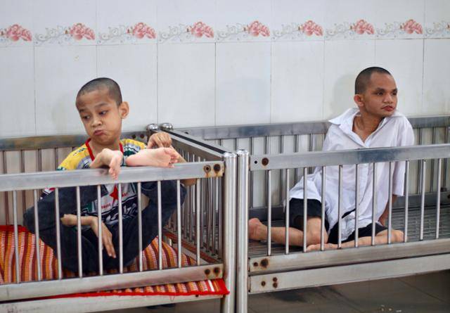 지난달 15일 베트남 호찌민시 구찌현 사회 보호 시설 '띠엔즈옌 복지원'에서 이곳에 머무는 고엽제 피해자들이 철제 침상 안에 앉아있다. 호찌민=허경주 특파원