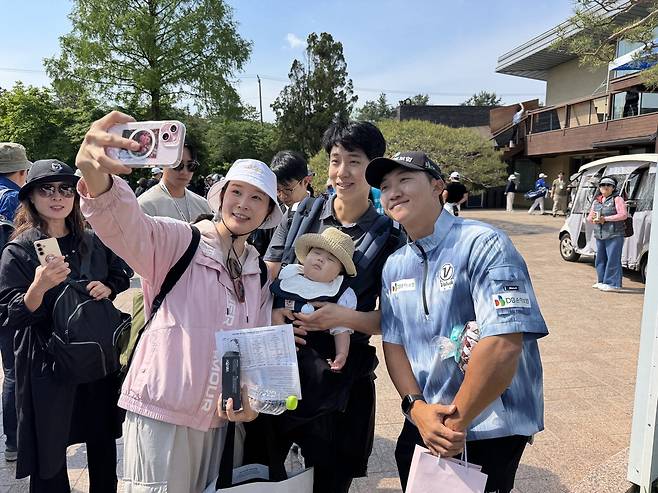 GS칼텍스 매경오픈을 방문한 갤러리들과 사진을 찍고 있는 2024년 챔피언 김홍택(맨 오른쪽).  성남 임정우 기자