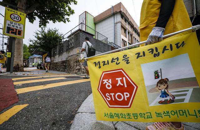 경찰 및 서울시청 직원 및 혜화초교 녹색어머니회원들이 2024년 8월 26일 서울 종로구 혜화초등학교 앞에서 2학기 개학맞이 어린이 보호구역 교통법규 위반 집중단속을 하고 있다. 뉴시스