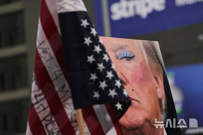 [로스앤젤레스=AP/뉴시스] 1일(현지 시간) 미 캘리포니아주 로스앤젤레스에서 열린 노동절 시위 중 도널드 트럼프 대통령을 조롱하는 풍자 사진이 보이고 있다. 2025.05.02.