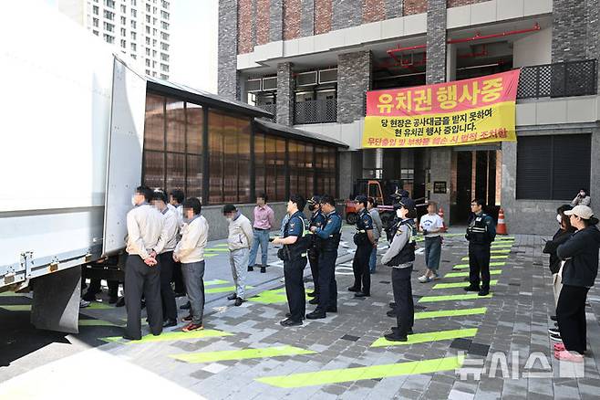 [광주=뉴시스] 박기웅 기자 = 2일 오후 광주 북구 운암동 한 신축아파트 입구에서 시공사 관계자들이 유치권 행사를 이유로 이삿짐 화물차를 막아서는 등 출입을 통제하자 입주 예정자가 항의하고 있다. 2025.05.02. pboxer@newsis.com