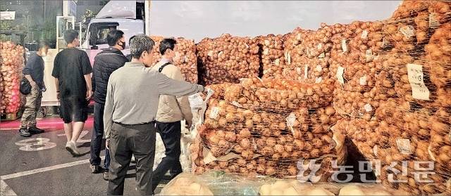 서울 가락시장 채소2동 1층 경매장 바깥에서 양파 경매가 이뤄지고 있다. 내부에서 미처 소화하지 못한 물량이 경매장 입구 화물차가 다니는 공간에 쌓여 있다.