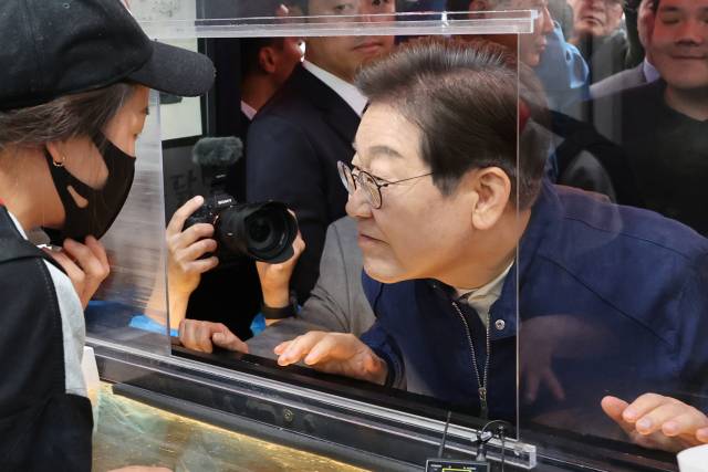 민심을 듣는 '골목골목 경청 투어'를 시작한 이재명 더불어민주당 대선 후보가 1일 경기도 북부 접경지역인 포천의 한 치킨집에서 상인과 대화하며 귀를 기울이고 있다. 연합뉴스