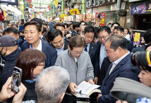 ‘골목골목 경청투어 : 동해안벨트편’에 나선 이재명 더불어민주당 대통령 후보가 3일 오전 강원 속초시 중앙로 속초관광수산시장에서 한 시민이 건넨 문서를 읽고 있다.(사진=뉴스1)