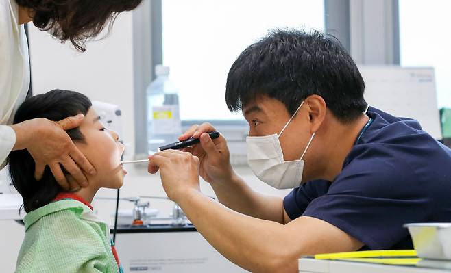 2일 오전 전남 곡성군 보건의료원에서 소아과 전문의 최용준씨가 한 아이의 입에 펜라이트를 비춰 보며 진료를 하고 있다. 최씨는 1960년 소아과 전문의 제도가 생긴 이래 곡성에 상주하는 첫 소아과 전문의다./김영근 기자