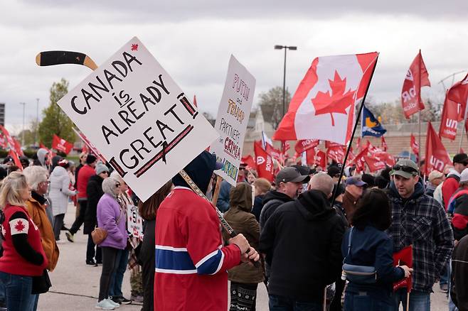 지난달 26일 캐나다 온타리오주에서 미국의 관세 부과에 항의하는 시위대가 캐나다 국기와 피켓을 들고 행진하고 있다. /AFP연합뉴스