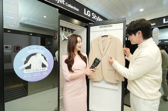 LG전자 고객이 스타일러를 사용한 뒤 의류의 오염도를 확인하며 위생 기능을 체험하고 있다. [사진=LG전자]