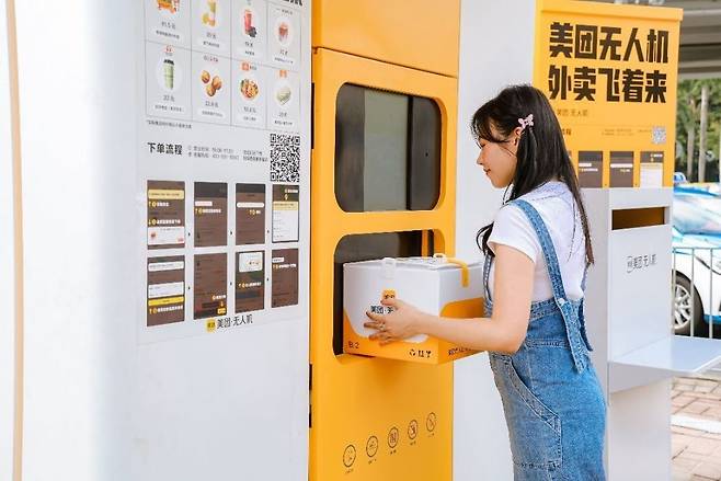 드론이 배달한 음식을 수령하는 주문자 / 사진=메이퇀