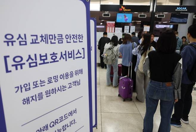 인천국제공항 제1여객터미널 출국장에 마련된 SK텔레콤 로밍센터에서 여행객들이 유심 교체 서비스를 받기 위해 대기하고 있다. 연합뉴스