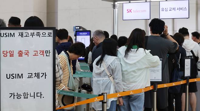 1일부터 엿새간 이어지는 황금연휴를 앞둔 30일 인천국제공항 제1여객터미널 SK텔레콤 로밍센터에서 출국자들이 유심 교체를 위해 대기하고 있다. 연합뉴스.