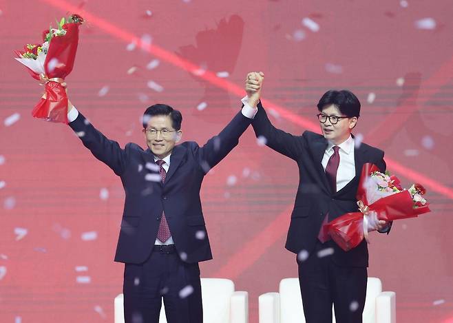 국민의힘 대선 후보로 선출된 김문수 후보가 3일 경기 고양시 킨텍스에서 열린 국민의힘 전당대회에서 꽃다발을 받은 뒤 한동훈 후보와 함께 인사하고 있다. 연합뉴스