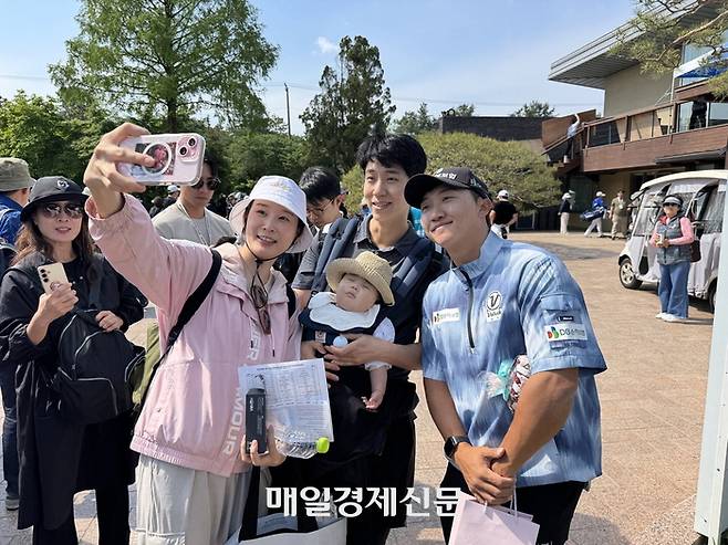 GS칼텍스 매경오픈을 방문한 갤러리들과 사진을 찍고 있는 2024년 챔피언 김홍택(맨 오른쪽). 성남 임정우 기자