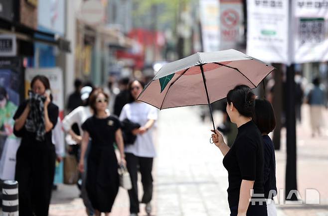 [대구=뉴시스] 이무열 기자 = 대구 낮 최고기온이 29도까지 오르며 초여름 날씨를 보인 18일 대구 중구 동성로에서 한 시민이 양산으로 햇빛을 가린 채 길을 걷고 있다. 2025.04.18. lmy@newsis.com