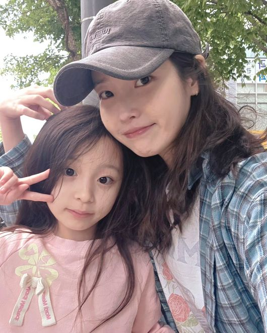 넷플릭스 드라마 ‘폭싹 속았수다’ 출연 아역배우 안태린과 함께 포즈를 취한 아이유(오른쪽). 사진 안태린 어머니 SNS 캡처