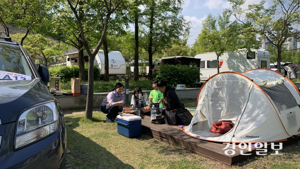 2일 오후 광교호수공원 가족캠핑장에서 떡볶이를 만들어 먹으며 즐거운 시간을 보내고 있는 조모(44)씨 가족의 모습. 2025.5.2 /유혜연기자 pi@kyeongin.com