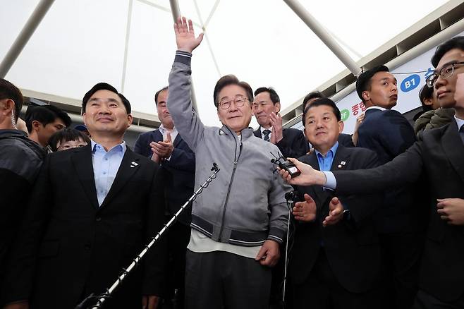 민심을 청취하는 ‘경청 투어’에 나선 이재명 더불어민주당 대선후보가 3일 강원도 속초중앙시장에서 상인 및 주민들에게 손을 들어 인사하고 있다. 뉴시스