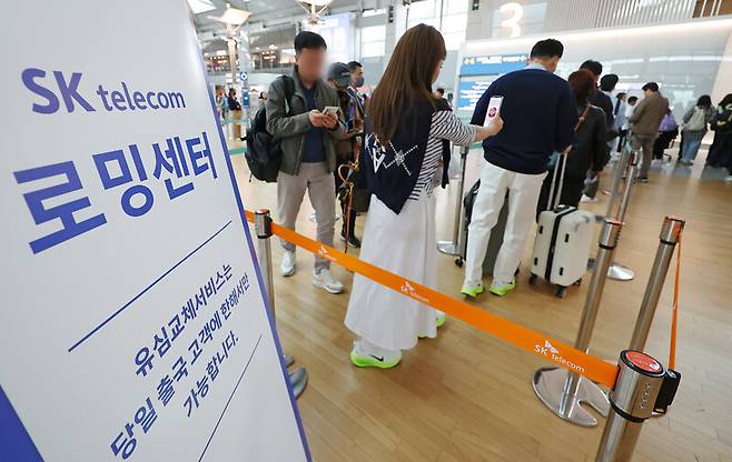 4일 인천국제공항 제1여객터미널 출국장에 마련된 에스케이(SK)텔레콤 로밍센터에서 출국자들이 유심 교체를 위해 줄을 서고 있다. 연합뉴스