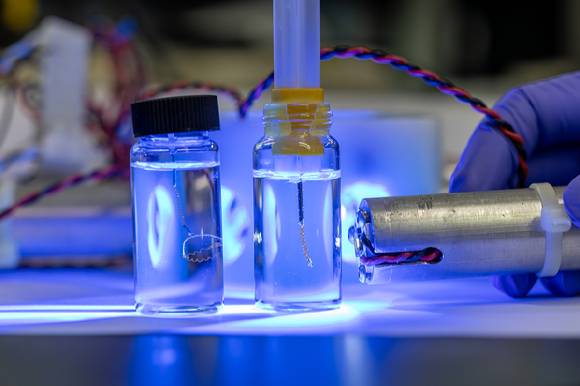 AC-LCE 소재로 만든 스프링 구조 인공근육에 자외선을 비춰 동작을 유도하고 있다. [사진=화학연]