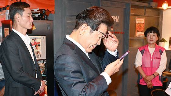 이재명 더불어민주당 대통령 후보가 지난 1일 서울 종로구의 한 음식점에서 열린 비전형 노동자 간담회에 참석해 대법원 선고를 확인하고 있다. 김성룡 기자