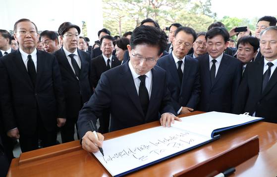 People Power Party presidential candidate Kim Moon-soo writes in the visitor's log at the Seoul National Cemetery in Dongjak District, southern Seoul, on May 4. [NEWS1]
