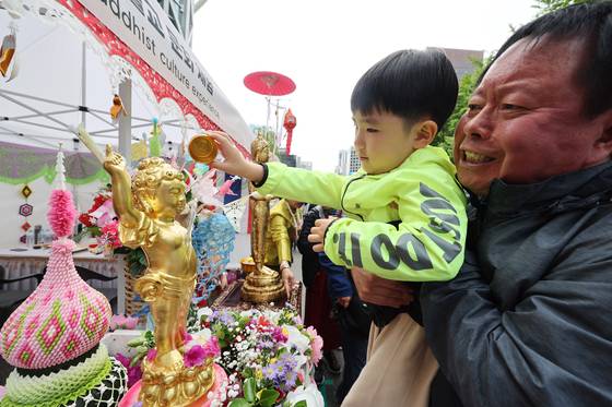 A child pours water over a golden Buddhist statue at an event to celebrate upcoming Buddha's birthday in Jongno District in central Seoul on April 27. Buddha's birthday falls on May 5 this year. [YONHAP]