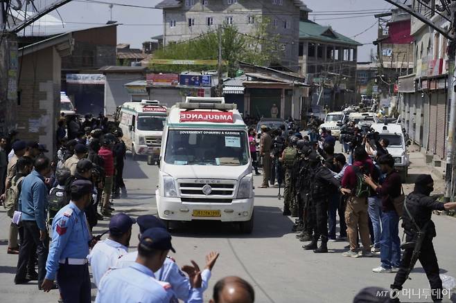 Police guard as ambulances carry bodies of tourists, in Srinagar, Indian controlled Kashmir, Wednesday, April. 23, 2025. (AP Photo/Mukhtar Khan)