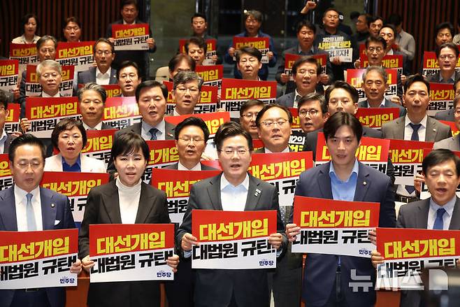 [서울=뉴시스] 고승민 기자 = 더불어민주당 박찬대 대표 직무대행 겸 원내대표와 의원들이 4일 서울 여의도 국회에서 열린 긴급 의원총회에서 피켓을 들고 구호를 외치고 있다. 2025.05.04. kkssmm99@newsis.com