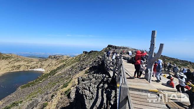 [제주=뉴시스] 임재영 기자 = 4일 오전 한라산 정상인 백록담에서 탐방객들이 선명하게 드러난 분화구 장관을 감상하고 있다. 2025.05.04. ijy788@newsis.com
